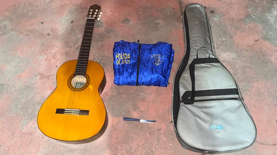 Huía por los techos de una casa con una guitarra clásica